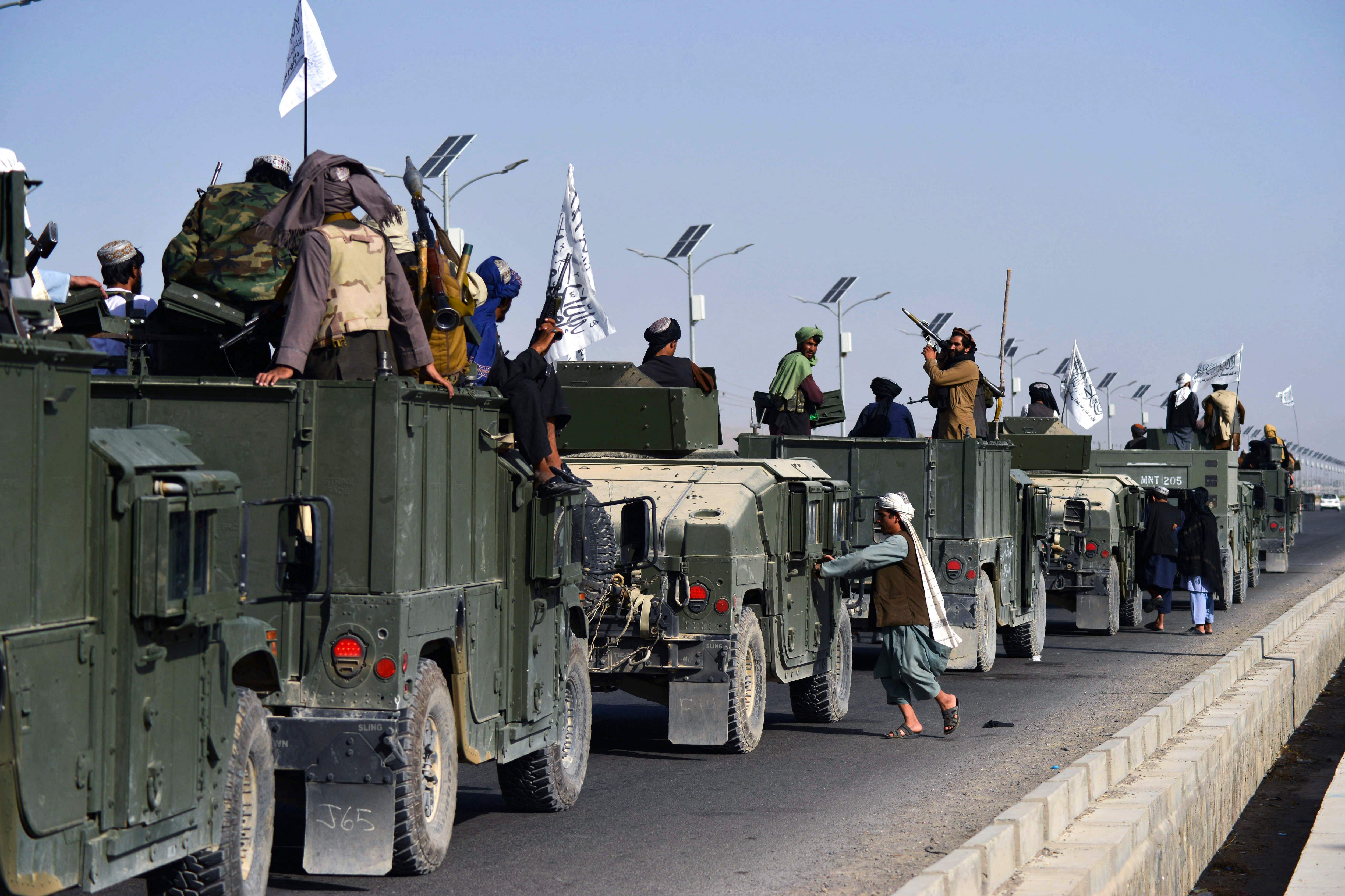 Taliban fighters atop Humvee vehicles prepare before parading along a road in Kandahar on September 1, 2021, to celebrate after the US pulled all its troops out of Afghanistan. (AFP File)