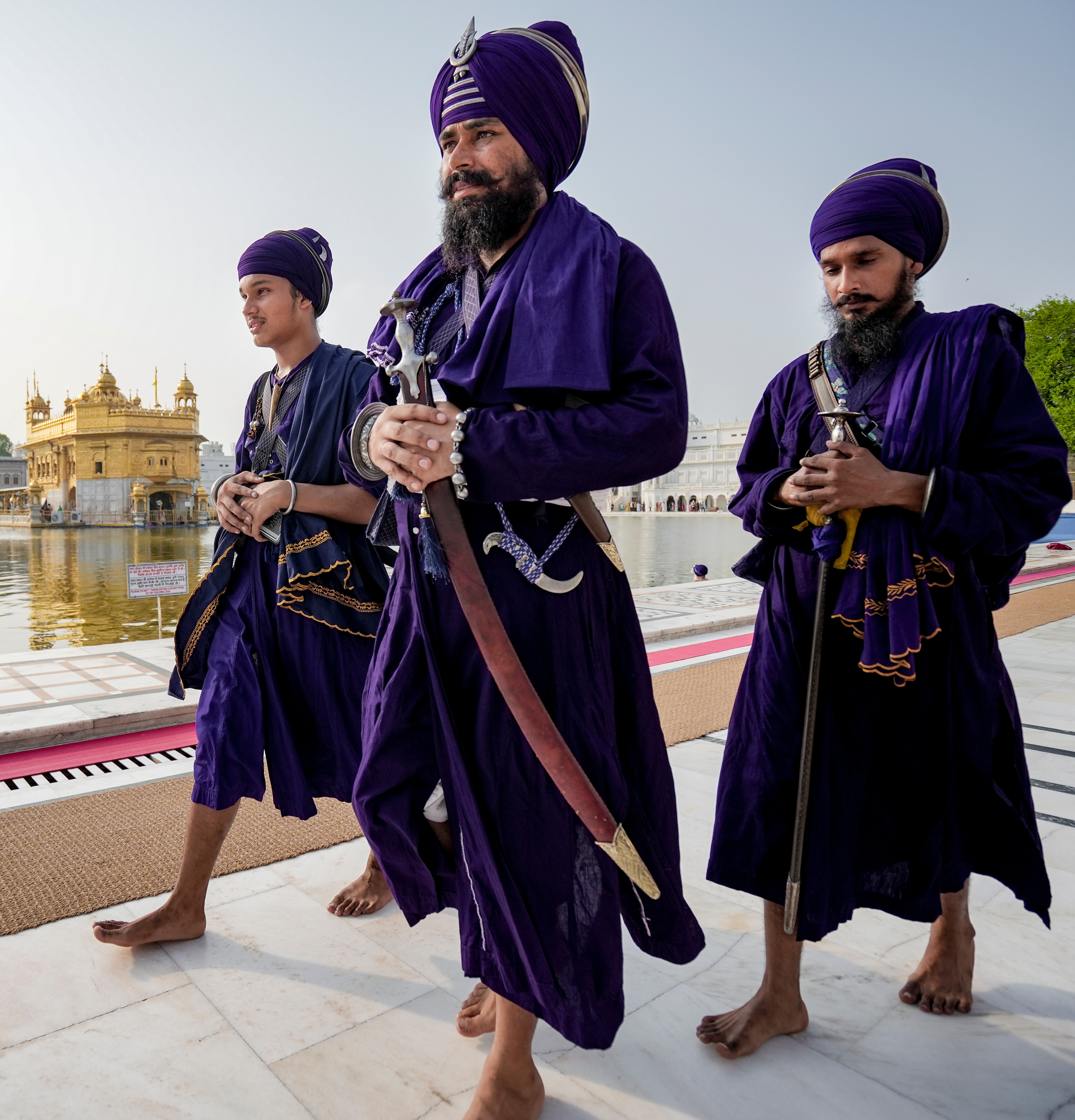 Nihang Sikhs carrying ceremonial kirpans walk along the parikrama at the Golden Temple, in Amritsar, Punjab, Friday, July 10, 2026. (PTI) Nihang Sikhs carrying ceremonial kirpans walk along the parikrama at the Golden Temple, in Amritsar, Punjab, Friday, July 10, 2026. (PTI)