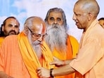 Chief minister Yogi Adityanath felicitates a seer during ‘Punya Smriti Mahamahotsav’ organised on the 23rd death anniversary of late Mahant Paramhans Ramchandra Das, in Ayodhya on Friday. (@myogiadityanath X/ANI Photo)