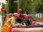 This handout photo distributed by the Indianapolis Fire Department shows first responders helping a resident in flood waters in Indianapolis, Indiana, on August 15.(AFP)
