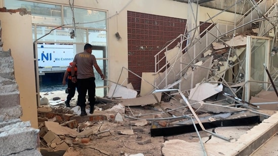 Rescuers inspect a heavily-damaged building at L. Say port, following an earthquake, in Sikka, East Nusa Tenggara province, Indonesia after a 7.7 magnitude earthquake