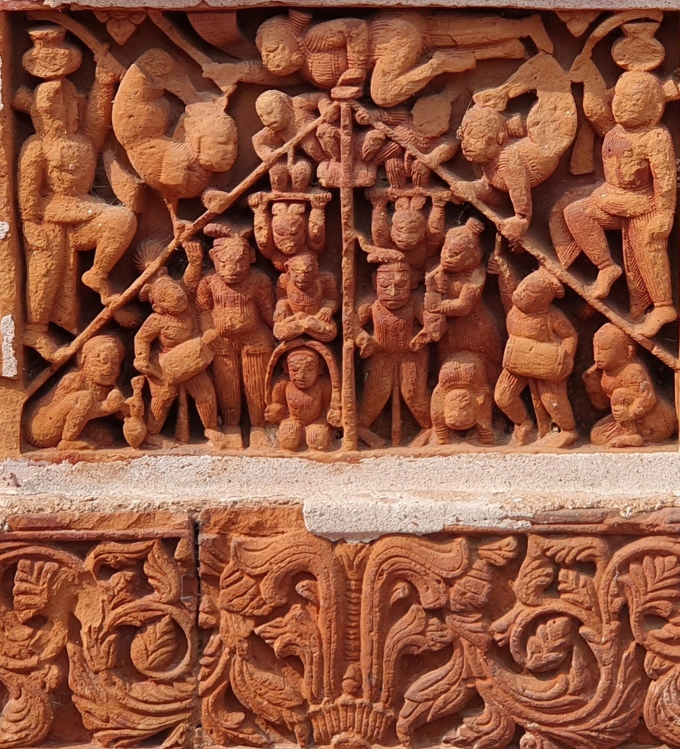 A terracotta panel shows acrobats performing at a temple in Atpur. Many of the intricate panels depict lighthearted moments from contemporary life. A terracotta panel shows acrobats performing at a temple in Atpur. Many of the intricate panels depict lighthearted moments from contemporary life.