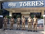Police personnel stand guard outside Torres Company’s office.