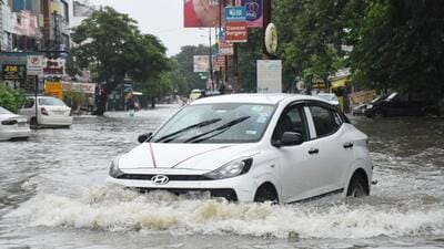 A car wades through a waterlogged road in Lucknow’s Aliganj area on Sunday. (Deepak Gupta/HT) A car wades through a waterlogged road in Lucknow’s Aliganj area on Sunday. (Deepak Gupta/HT)