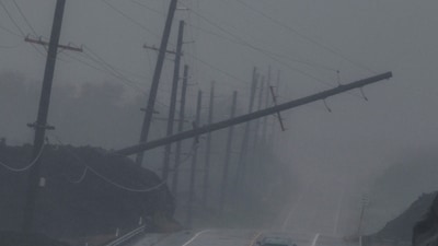 A vehicle drives near a downed utility pole dangling above Mamalahoa Highway during Hurricane Lala near Ocean View, Hawaii. (Stephen Lam/San Francisco Chroni) A vehicle drives near a downed utility pole dangling above Mamalahoa Highway during Hurricane Lala near Ocean View, Hawaii. (Stephen Lam/San Francisco Chroni)