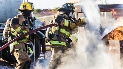 A large smoke plume rises over downtown Dallas as fire crews respond.