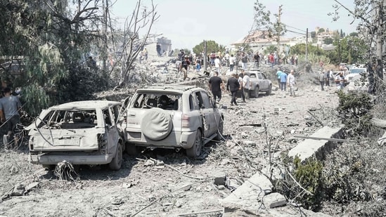 First aid responders and residents rush to the site of an Israeli airstrike that targeted the neighbourhood in the southern Lebanese village of Deir al-Zahrani on August 15 2026. 