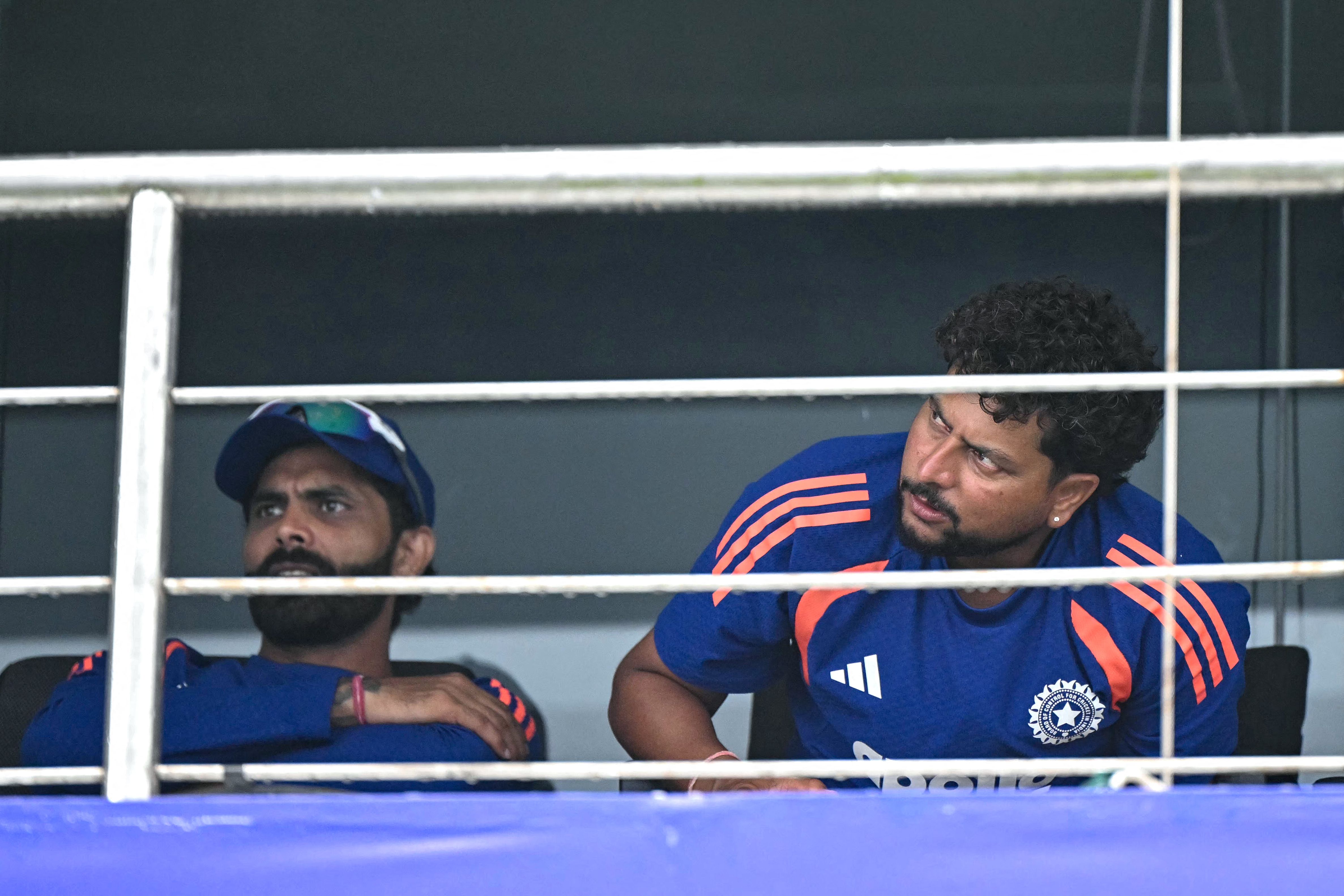 India's Kuldeep Yadav (R) and Ravindra Jadeja wait inside their dressing room as rain delays the start of play on second day of the first Test cricket match between Sri Lanka and India at the Galle International Stadium in Galle on August 16, 2026. (Photo by Ishara S. KODIKARA / AFP) (AFP)