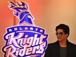 Shah Rukh Khan in front of the KKR logo. Shah Rukh Khan in front of the KKR logo.