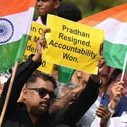 Protesters celebrate the resignation of Dharmendra Pradhan as Union education minister, in Mumbai last month.
