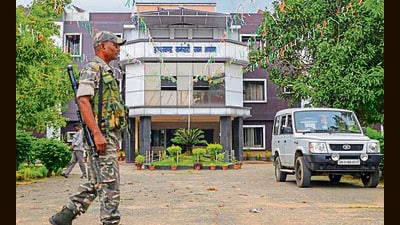 A security personnel stands guard outside the Jharkhand Staff Selection Commission (JSSC) headquarters at Namkum a CID team conducts a raid inside, in connection with the JSSC-CGL paper leak case, in Ranchi, Monday. (PTI)
