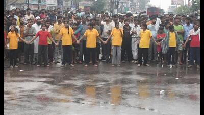 Girl students form a human chain and protest teacher shortage on Dubagga-Sitapur bypass amid rain in Lucknow on Monday. (HT Photo) Girl students form a human chain and protest teacher shortage on Dubagga-Sitapur bypass amid rain in Lucknow on Monday. (HT Photo)