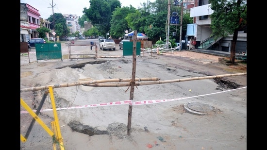 A stretch of road caved in at Vikas Nagar, Sector 2, in Lucknow on Monday, following heavy rainfall amid ongoing sewage work (Deepak Gupta/HT)