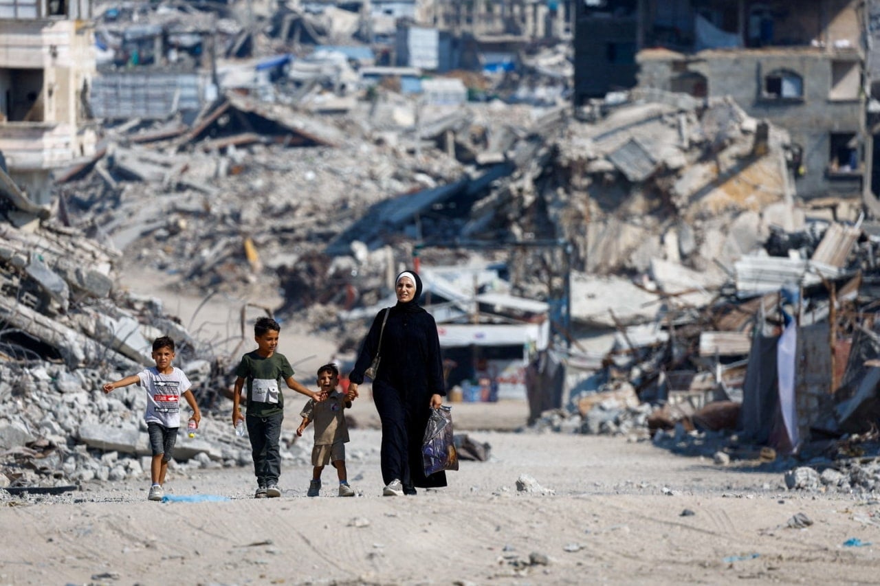 People walk past the rubble of residential buildings in Gaza City, People walk past the rubble of residential buildings in Gaza City,