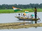 Children hold national flags and tricolour balloons as they row a boat on India's 80th Independence Day.