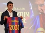 Spanish international footballer Rodri poses with a jersey bearing his name.