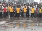 Girl students form a human chain and protest teacher shortage on Dubagga-Sitapur bypass amid rain in Lucknow on Monday. (HT Photo)