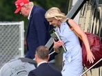 US President Donald Trump and aide Natalie Harp (R) exit Marine One on the Ellipse near the White House on August 16, 2026.