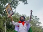Ranchi: Student leader Devendra Nath Mahto, wrapped in the national flag, holds a portrait of Jharkhand Mukti Morcha (JMM) chief Shibu Soren.(PTI File)
