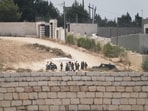 Israeli settlers patrol a road in front of besieged Palestinian houses, in the occupied West Bank village of Qusra, south of Nablus, Monday, Aug. 17, 2026.(AP)