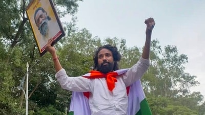 Ranchi: Student leader Devendra Nath Mahto, wrapped in the national flag, holds a portrait of Jharkhand Mukti Morcha (JMM) chief Shibu Soren. (PTI File) Ranchi: Student leader Devendra Nath Mahto, wrapped in the national flag, holds a portrait of Jharkhand Mukti Morcha (JMM) chief Shibu Soren. (PTI File)