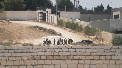Israeli settlers patrol a road in front of besieged Palestinian houses, in the occupied West Bank village of Qusra, south of Nablus, Monday, Aug. 17, 2026. (AP) Israeli settlers patrol a road in front of besieged Palestinian houses, in the occupied West Bank village of Qusra, south of Nablus, Monday, Aug. 17, 2026. (AP)