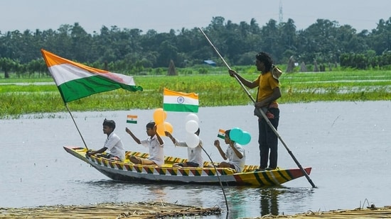 Children hold national flags and tricolour balloons as they row a boat on India's 80th Independence Day. (ANI Photo)