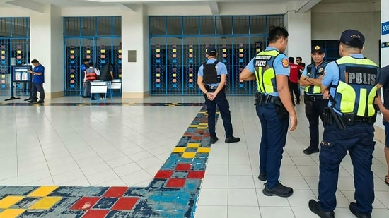 Philippine police gather at a school following a shooting in Zamboanga on August 18, 2026. A student was shot dead at a high school in the southern Philippines on August 18 before the alleged killer took his own life, police said. (Photo by Roel Parreno / AFP) (AFP)