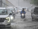 Vehicles wade through a waterlogged stretch following heavy rainfall in the national capital in New Delhi