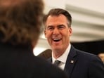 FILE - Oklahoma Gov. Kevin Stitt speaks with an individual following an event at the National Governors Association Winter Meeting, Feb. 19, 2026, in Washington.