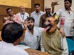 Khandwa Municipal Corporation Leader of Opposition Deepak Mullu Rathore argues with a municipal official while a supporter dressed in a dog costume sits beside him