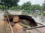 The caved-in portion of the Sector 26–28 dividing road near the transport light point. (Ravi Kumar/HT)