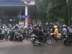 Huge crowd outside a petrol pump in Chandigarh's Sector 10 amid heavy rain after 'petrol langar' announcement.