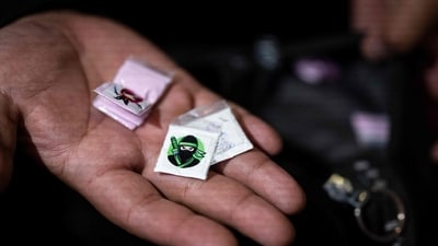 File image: An officer holds small packets of cocaine and tusi seized during an operation (AFP) File image: An officer holds small packets of cocaine and tusi seized during an operation (AFP)