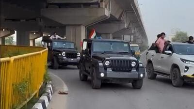 The footage reportedly shows a convoy including a black Mahindra Thar stopping on the busy expressway while a man waves the tricolour. (Screengrab) The footage reportedly shows a convoy including a black Mahindra Thar stopping on the busy expressway while a man waves the tricolour. (Screengrab)