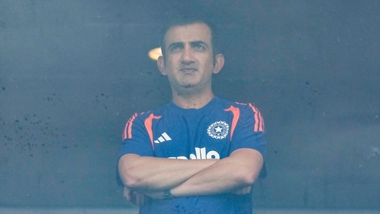 India's coach Gautam Gambhir waits amid a match delay.