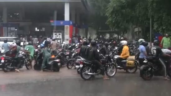 Huge crowd outside a petrol pump in Chandigarh's Sector 10 amid heavy rain after 'petrol langar' announcement.
