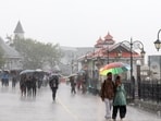 People walk under umbrellas amid heavy monsoon showers, in Shimla last week.