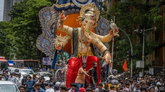 Devotees carry the Lord Ganesha idol ahead of Ganesh festival from Parel workshop. (Satish Bate/ Hindustan Times)