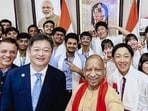 Chief minister Yogi Adityanath poses for photographs with students from Japan and India during an interaction, in Lucknow. (@CMOfficeUP/X via PTI Photo)