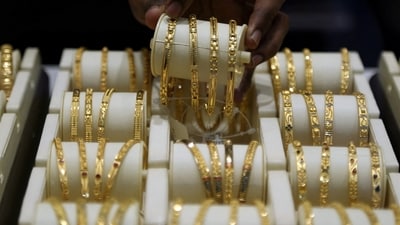 A salesman arranges gold bangles inside a jewellery showroom. (REUTERS)