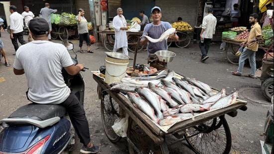 At Chitli Qabar Chowk, street trader Parvez sells fish from a cart stationed at the centre of the square. (HT Photo)