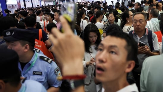 Visitors walk past booths at an exhibition hall during the 2026 World Robot Conference, in Beijing, China August 21, 2026. REUTERS/Tingshu Wang