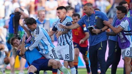FILE - Argentina's Leandro Paredes (5) knocks down Spain's Gavi (9) during scuffle. (AP Photo/Julio Cortez)