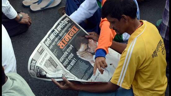 Shiv-Sena-supporters-read-the-party-s-official-newspaper-Saamna-with-the-front-page-news-of-the-demise-of-Shiv-Sena--chief-Bal-Thackeray-during-his-funeral-procession-in-Mumbai-AFP-Photo