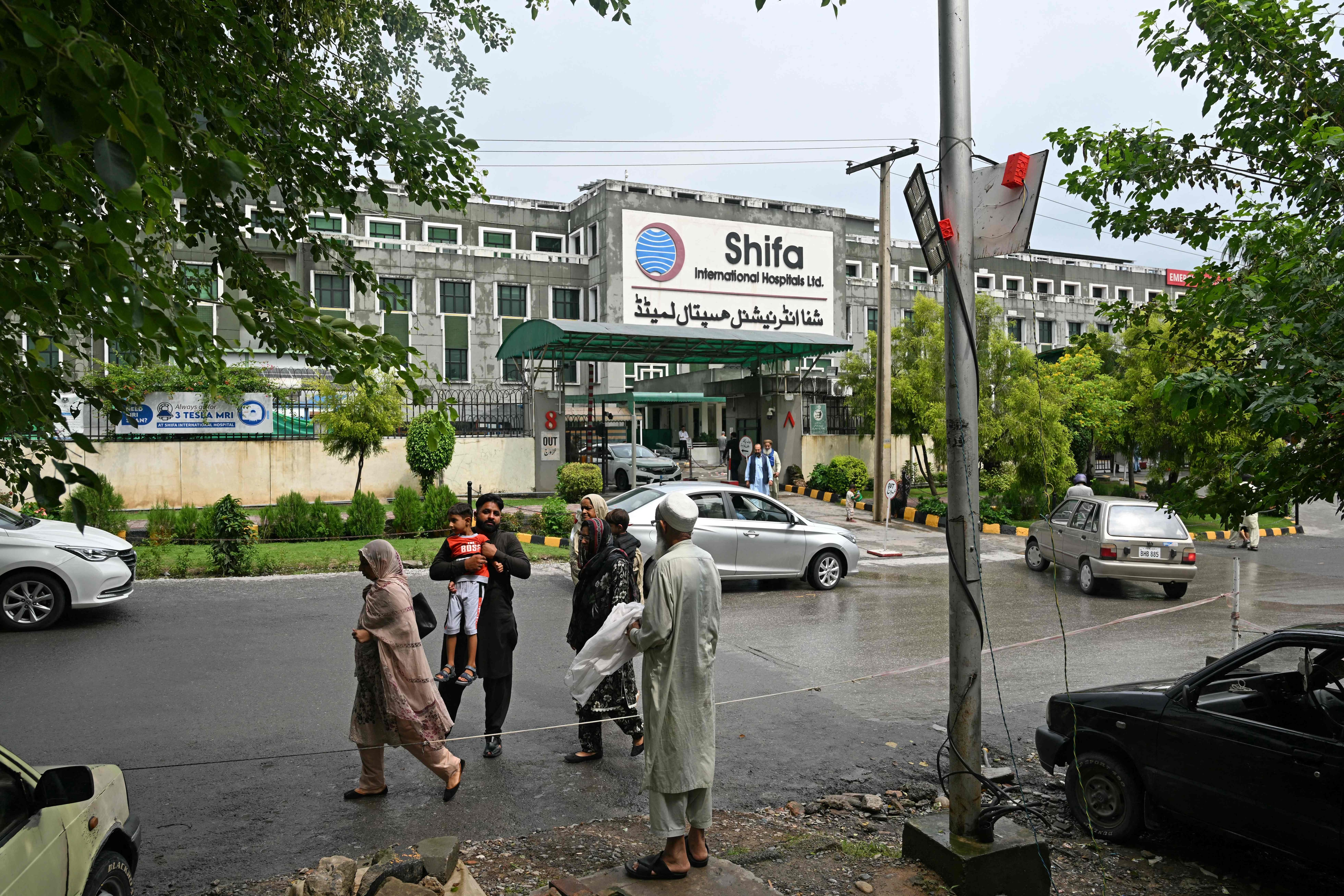 People walk past Shifa International Hospital following Pakistan's former prime minister Imran Khan's medical examination in Islamabad on August 21, 2026. (AFP)