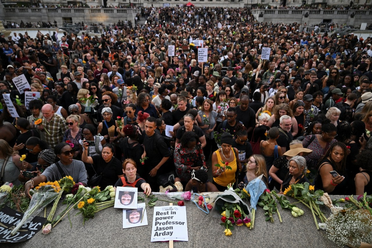 People in London lay flowers down during a vigil to remember former Cambridge Professor Jason Arday.