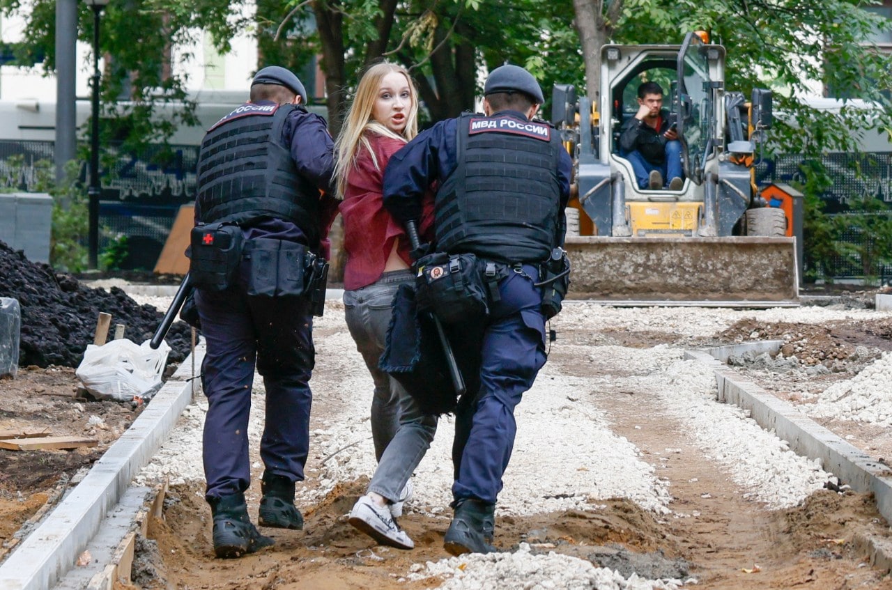Police officers lead away a Yabloko supporter outside a Moscow courthouse where the party appealed its election ban.