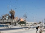 People run for cover, as debris flies through the air, during an Israeli strike, carried out after the Israeli military warned residents to evacuate the area, Al-Zawayda, in the central Gaza Strip, (Reuters)