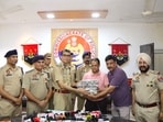 Jalandhar commissioner of police Satinder Singh handing over the recovered money to the robbery victim. (HT) Jalandhar commissioner of police Satinder Singh handing over the recovered money to the robbery victim. (HT)
